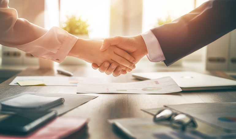 Man and woman are shaking hands in office. Collaborative teamwork.